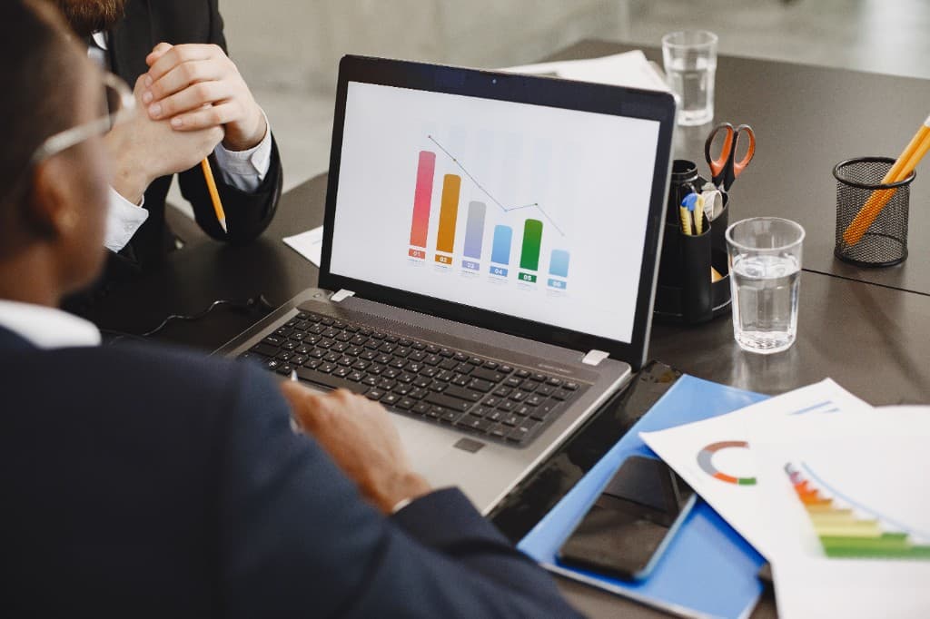 Sales team reviewing CRM pipeline data and charts on a laptop